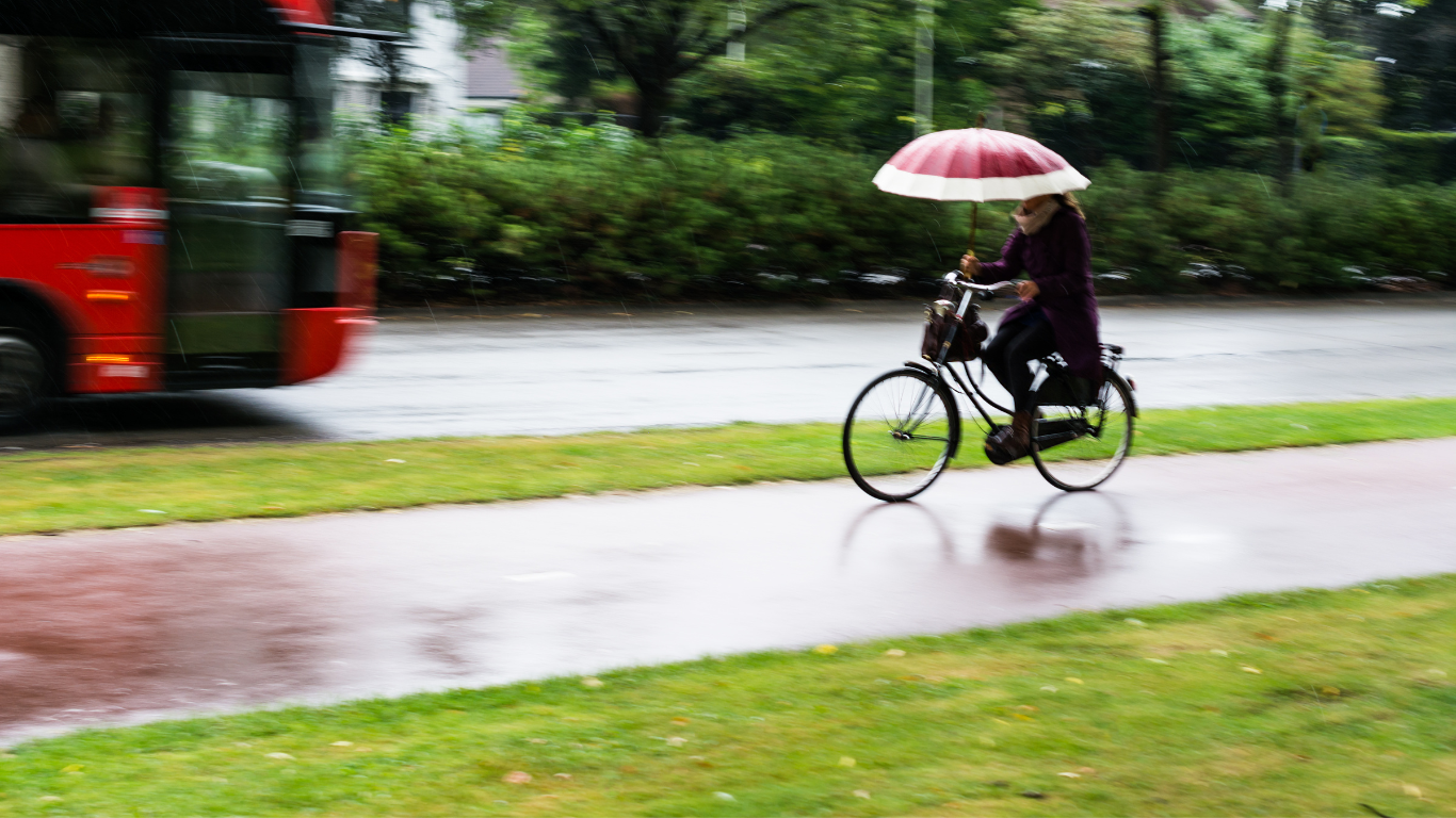 Fietser in de regen met paraplu