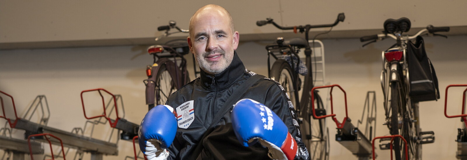 Pascal Heppenhuis bokscoach op de fiets - staat met bokshandschoenen in de fietsenstalling - december 2023