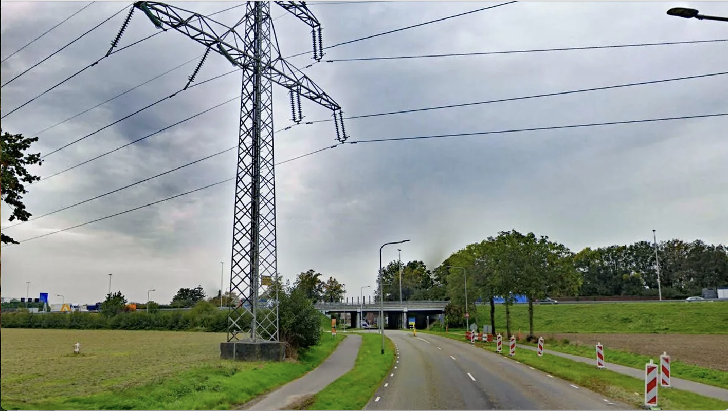 Holtummerweg bij Holtum met akkers aan beide kanten, een elektriciteitsmast en grijze lucht