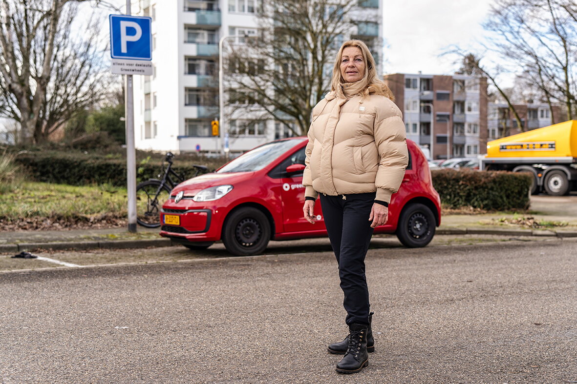 Gea Top poseert voor een rode Greenwheels deelauto in Kerkrade