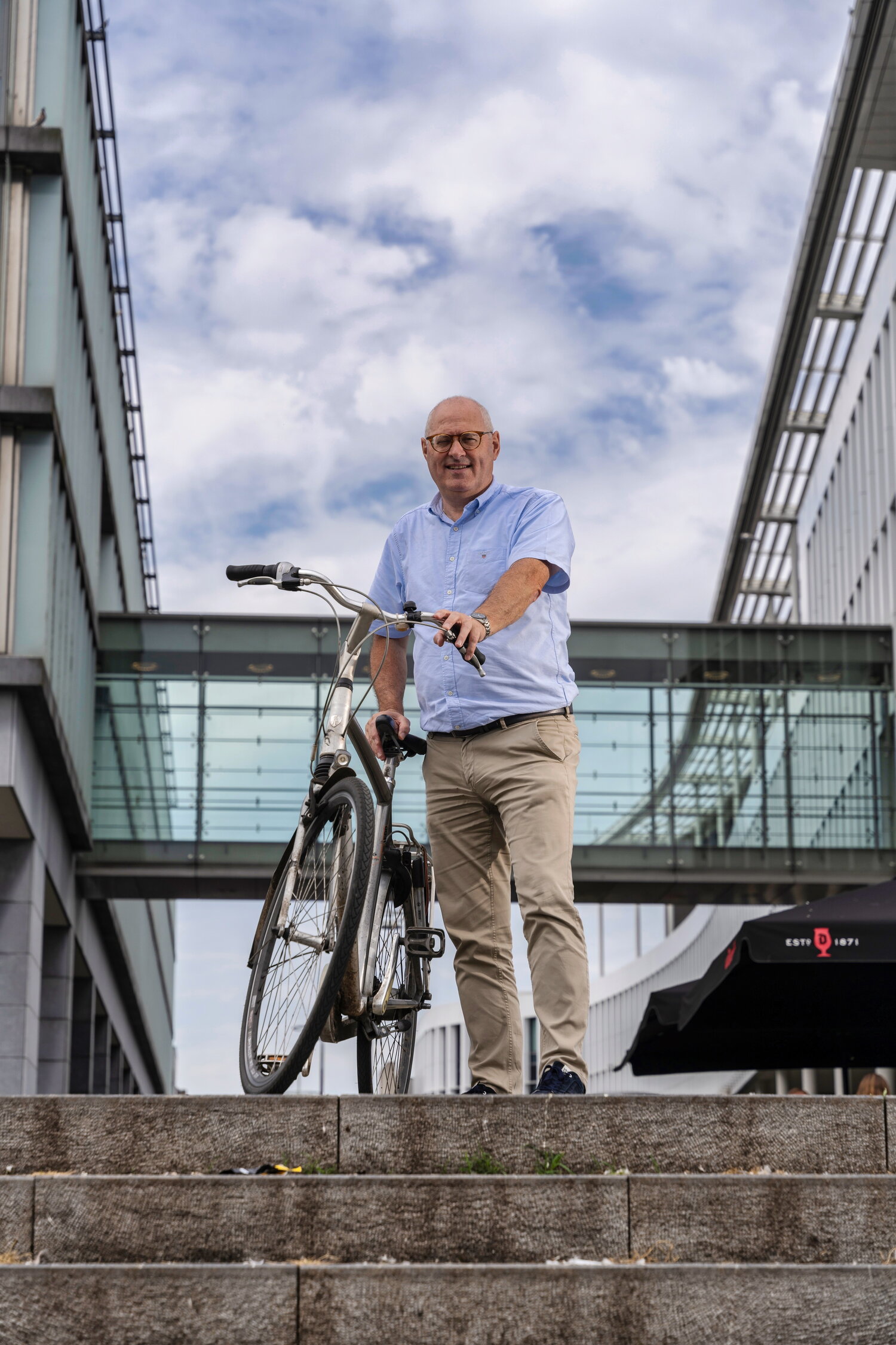 Rob Starren van gemeente Maastricht op de fiets, voor het Stadskantoor
