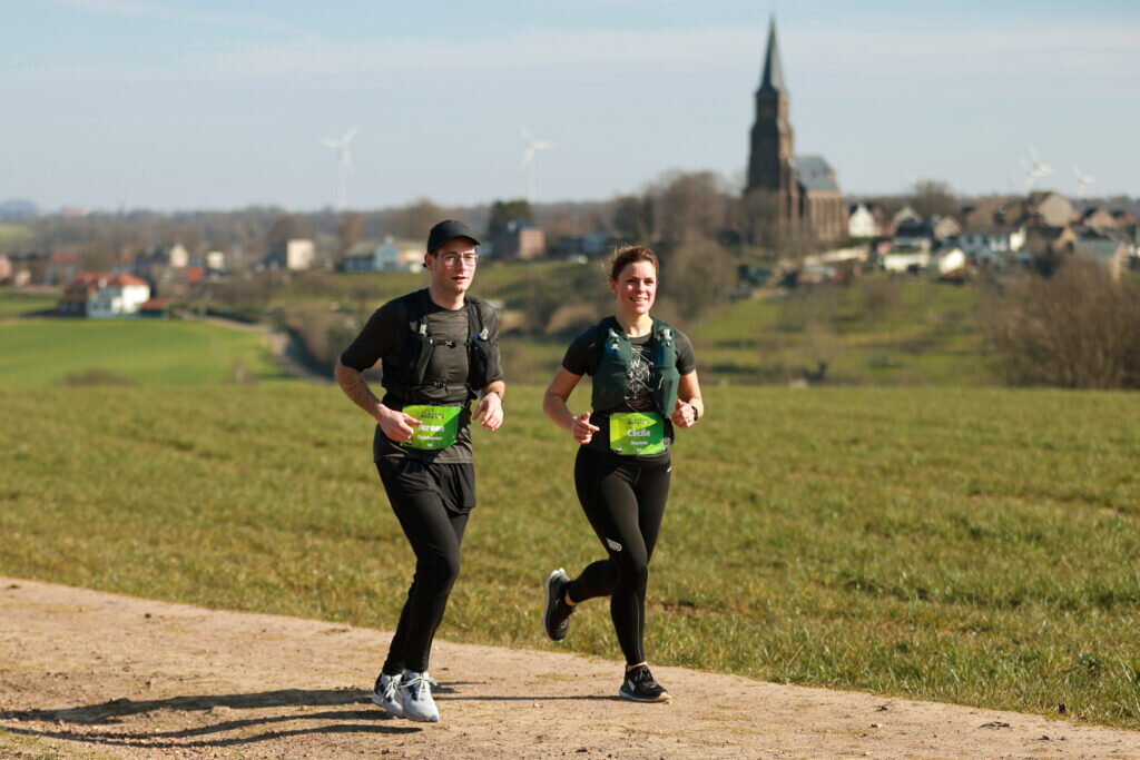Renners man en vrouw Heuvelland Marathon in Zuid-Limburgse landschap