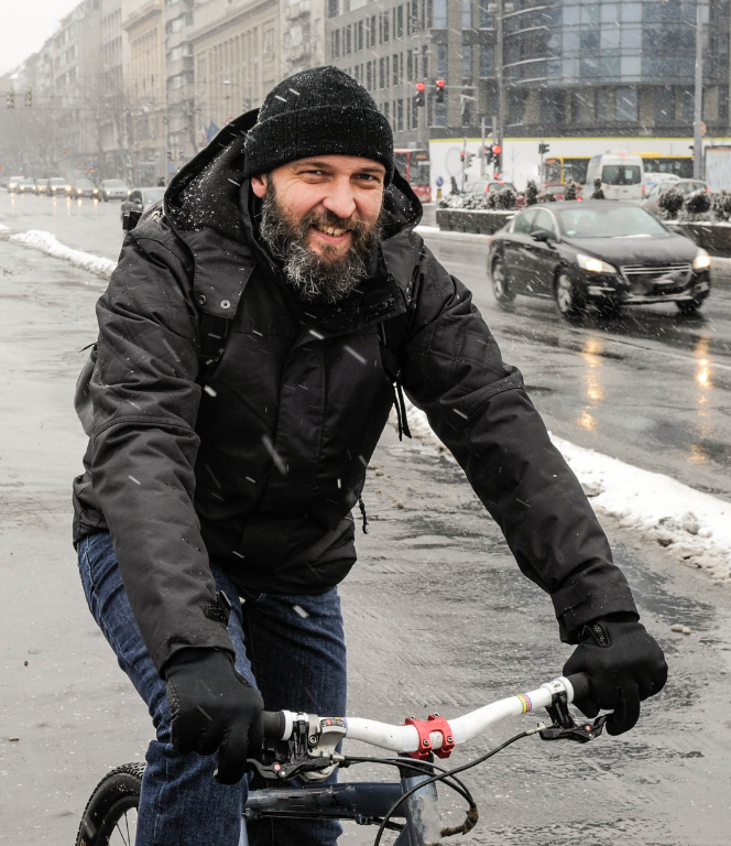 Man fietst door de sneeuw in de stad