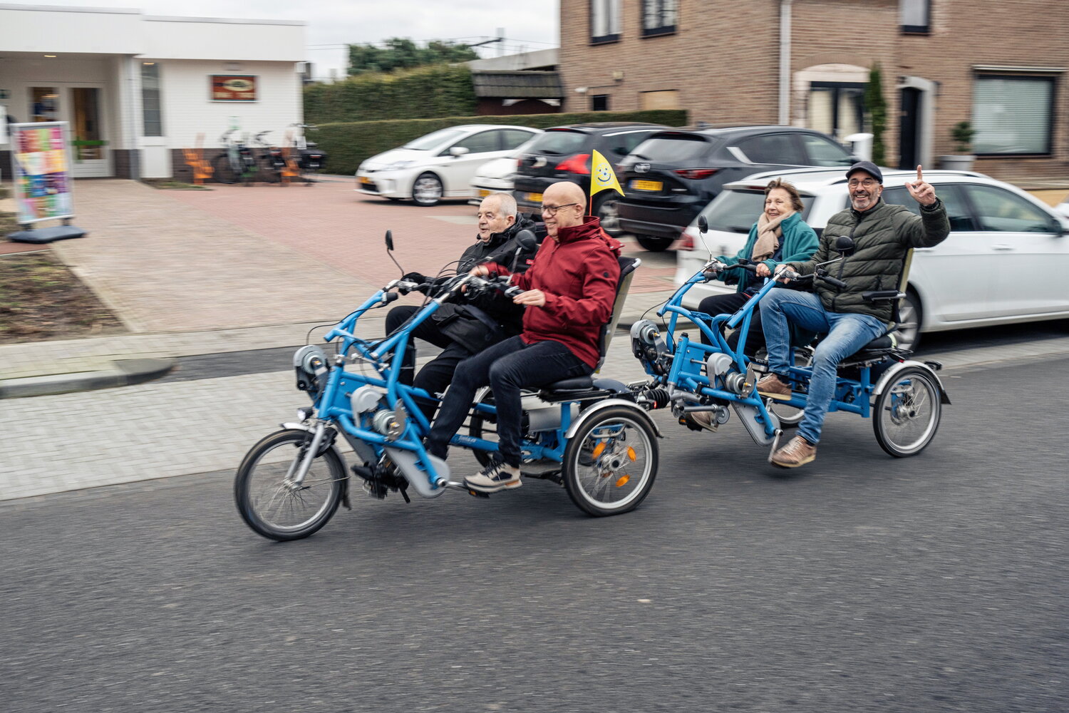 Fietsmaatjes Eijsden op de weg met Maurice met pet die zwaait