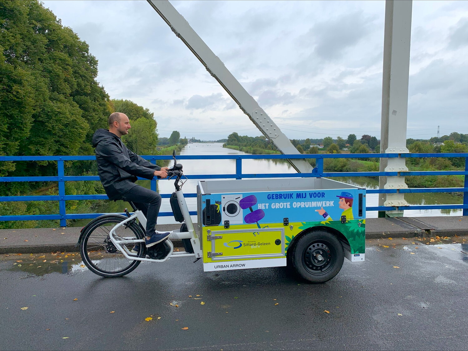 De e-bakfiets met extra grote laadbak,van gemeente Sittard-Geleen onderweg.