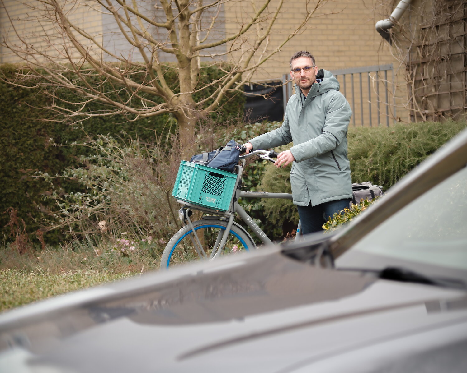 Wouter Schaekers met zijn fiets. Op de voorgrond staat zijn elektrische auto